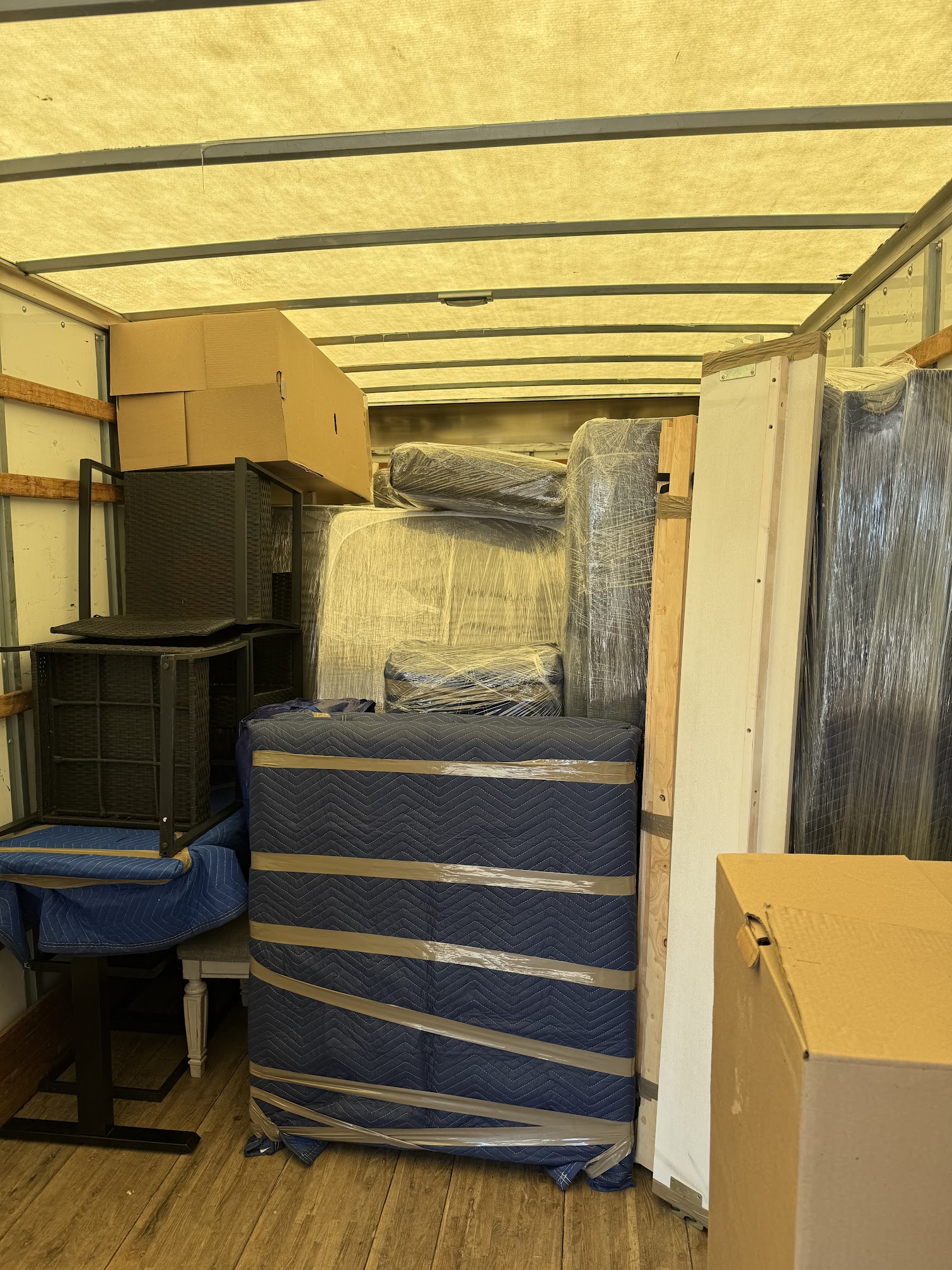 Moving team protecting furniture with blankets and wrap